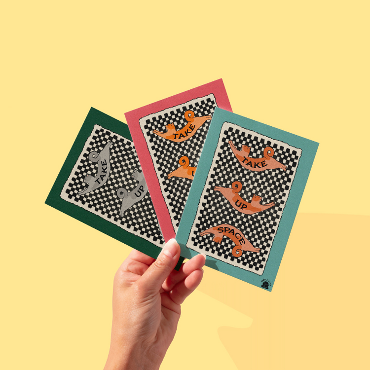 hand holding 3 checkered prints with cats laying across them that says "take up space"